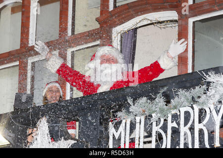 Stockton Heath, Cheshire, Regno Unito. 30 Novembre 2018 - Le luci di Natale sono stati accesi in Victoria Square, Stockton Heath, Cheshire, Inghilterra dove centinaia di persone hanno assistito ad una locale scuola di cantare le canzoni natalizie e Babbo Natale gettare i dolciumi ai bambini attraverso una tempesta di neve artificiale. Faisal Rashid, il membro del Parlamento per Warrington sud, era in credito di presenze: John Hopkins/Alamy Live News Foto Stock