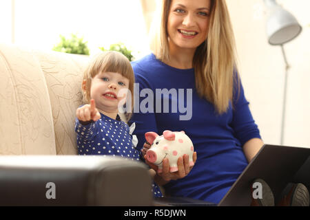 Bambino bambina braccio mettendo in moneta piggybank Foto Stock