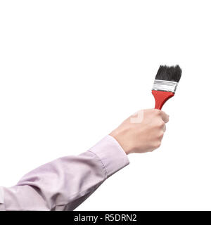La mano che regge un pennello Foto Stock