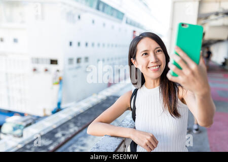 Donna prendendo selife dal telefono cellulare nel terminale di crociera Foto Stock