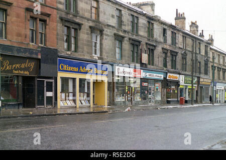 Tenements e negozi sulla strada Kilbowie in Clydebank. 1981 Foto Stock