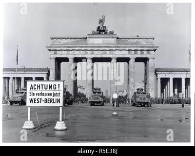 Didascalia originale: Berlino Est mettere dietro la cortina di ferro a Berlino, agosto 1961 - In un ultimo tentativo di fermare il flusso di rifugiati in fuga da Germania est attraverso Berlino ovest, il governo comunista della zona sovietica spostato su agosto xiii al blocco di Berlino Est con truppe, blocchi stradali e filo spinato. Armati pesantemente e Oriente le forze tedesche, sostenuto da esercito sovietico unità, pattugliato il settore Est per evitare disturbi mentre la libera ad ovest i berlinesi, adirato per l'azione comunista, dimostrato sul loro lato del confine in solidarietà con coloro che ora tagliati fuori da qualsiasi contatto con l'Occidente. Militar Foto Stock