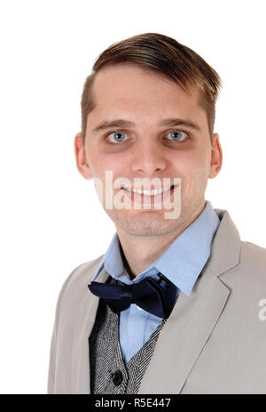 Una chiusura immagine ritratto di una giovane uomo sorridente in una giacca grigio e blu bow tie e occhi blu, isolato per sfondo bianco Foto Stock