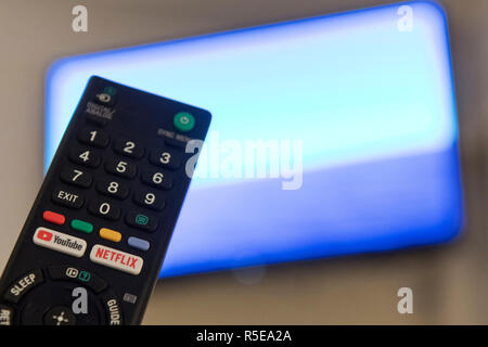Un telecomando con Netflix e YouTube pulsanti è raffigurata da una smart tv in una camera da letto a casa nel Regno Unito. Novembre 2018. Foto Stock