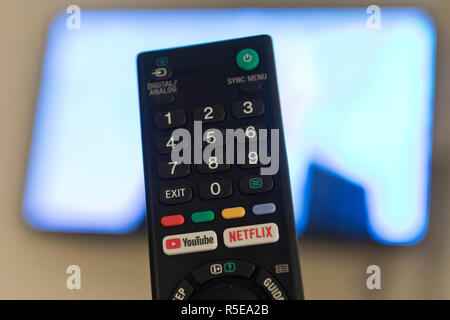Un telecomando con Netflix e YouTube pulsanti è raffigurata da una smart tv in una camera da letto a casa nel Regno Unito. Novembre 2018. Foto Stock