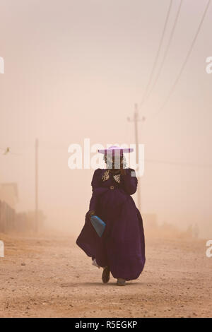 Herero donna in tempesta di polvere, Opuwo, Namibia Foto Stock