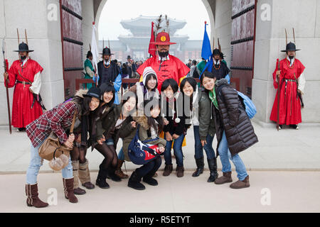 Corea del Sud, Seoul, il Palazzo Gyeongbokgung, ragazze in posa con guardie cerimoniali Foto Stock