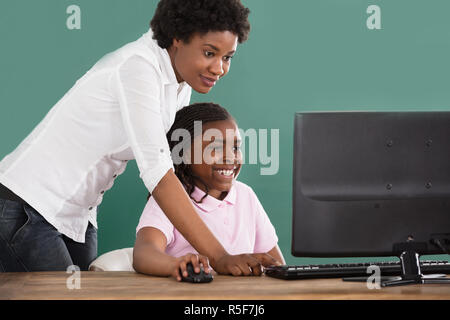 Insegnante e studente utilizzando il computer Foto Stock