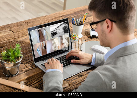 Imprenditore controllo video TVCC su Laptop Foto Stock