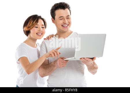 Sorridente coppia giovane utilizzando computer portatile isolato su bianco Foto Stock