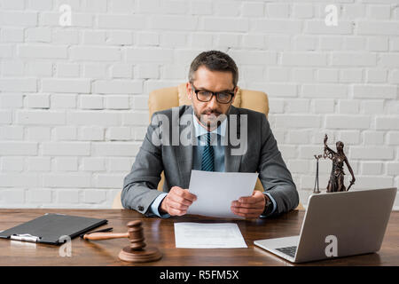 Grave giudice maschio lavorano con documenti di office Foto Stock