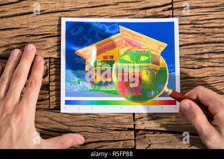 Persona analizzando la perdita di calore di una casa Foto Stock