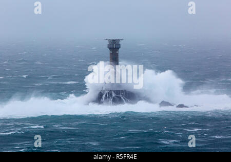 Grandi onde si infrangono nella Longships Lighthouse off Lands End Cornwall Foto Stock