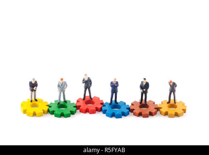 Figure aziendali su ingranaggi colorati isolati su sfondo bianco Foto Stock