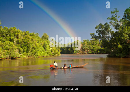 Venezuela, Delta Amacuro, Delta Orinoco, Warao persone in barca sul fiume Nararina con arcobaleno nel cielo in tempesta Foto Stock