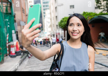 Donna prendendo in selfie Pottinger Street Foto Stock