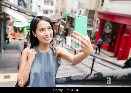 Donna prendendo foto con il cellulare in Pottinger Street Foto Stock