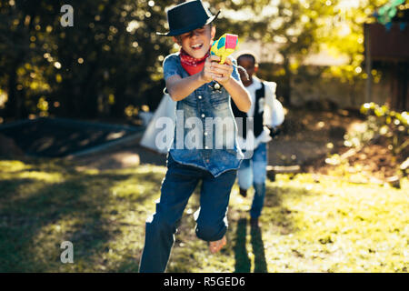 I ragazzi all'aperto divertendosi con acqua pistole. Ragazzi in cortile a giocare con le pistole ad acqua. Foto Stock