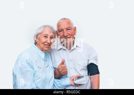 Apparecchiatura di misura la pressione nelle mani di una donna anziana. Foto Stock
