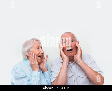 La coppia di anziani sorpreso sollevando entrambe le mani Foto Stock