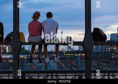 Coppia giovane sulla data romantico sulla ferrovia urbana bridge, Monaco di Baviera, Germania. Foto Stock