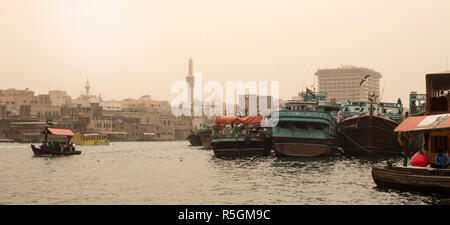 Dubai Creek con tradizionali navi cargo e dhows in una tempesta di sabbia, Emirati Arabi Uniti Foto Stock