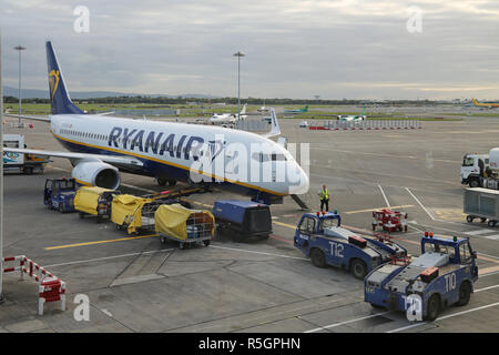 A Ryanair Boeing 737 parchi sul piazzale dell'Aeroporto Internazionale di Dublino, Irlanda, terminale 2. Mostra il carico bagagli e veicoli di servizio. Foto Stock