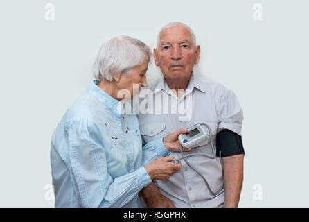 Apparecchiatura di misura la pressione nelle mani di una donna anziana. Foto Stock