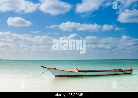 Canoa galleggianti su acque calme sotto il bel cielo azzurro Foto Stock