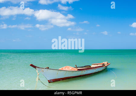 Canoa galleggianti su acque calme sotto il bel cielo azzurro Foto Stock