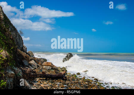 Onde che si infrangono sulla spiaggia sassosa, formando uno spray Foto Stock