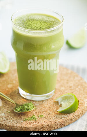 Un vetro con un frullato di verde con banana, avena, latte di calce e matcha tè. Il concetto di vegetariano e una sana dieta alimentare. Foto Stock