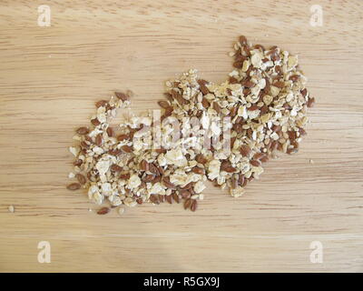 Miscela di semi con i fiocchi d'avena,lino e i semi di sesamo su una tavola di legno Foto Stock