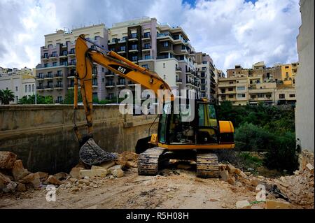 Mellieha, Malta - 4 Ottobre 2018: Grande escavatore e il sito di demolizione Foto Stock
