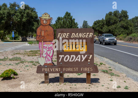 Un Smokey Bear prevenzione incendi cartello stradale impostato su 'Alto' in California, Stati Uniti. Foto Stock