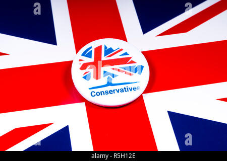 London, Regno Unito - 18 Novembre 2018: un partito conservatore pin distintivo sopra la bandiera del Regno Unito. Foto Stock