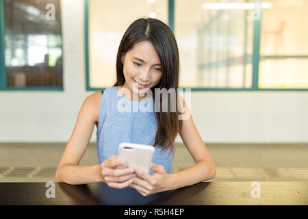 Donna che utilizza il telefono cellulare nel coffee shop Foto Stock