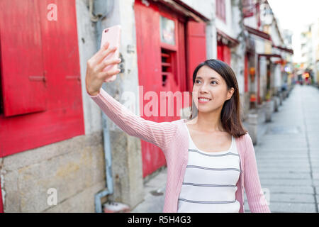 Donna prendendo selfie in Rua da Felicidade di Macao Foto Stock