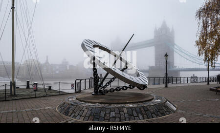 St Katharine Dock Dial e il Tower Bridge nella nebbia Foto Stock