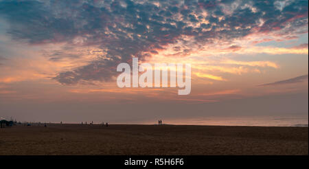 Silhouette di persone a Puri Beach al momento del sorgere del sole. Foto Stock