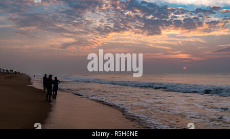 Silhouette di persone a Puri Beach al momento del sorgere del sole. Foto Stock