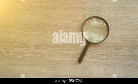 Lente di ingrandimento in laminato grigio Sfondo. Effetto sole Foto Stock