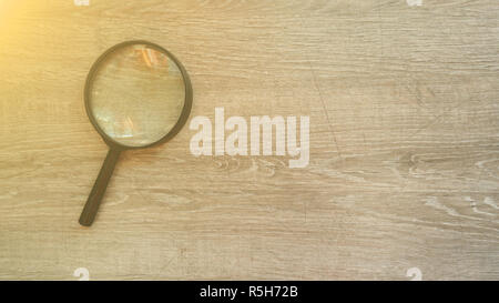 Lente di ingrandimento in laminato grigio Sfondo. Effetto sole Foto Stock