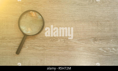 Lente di ingrandimento in laminato grigio Sfondo. Effetto sole Foto Stock