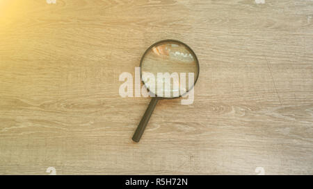 Lente di ingrandimento in laminato grigio Sfondo. Effetto sole Foto Stock