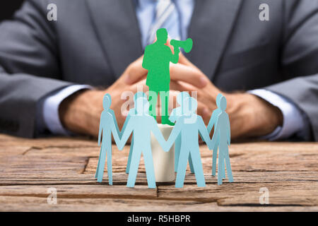 Executive parlare attraverso il megafono circondato dal Team Foto Stock