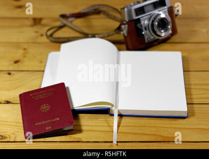 Diario di viaggio, passaporto e una vecchia macchina fotografica su un tavolo di legno Foto Stock