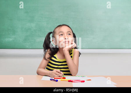 Pretty asian bambina con matite di colore disegno sulla carta Foto Stock