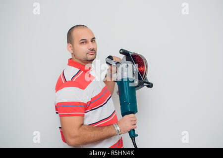 Lavoratore edile con un perforatore urlare su sfondo bianco Foto Stock