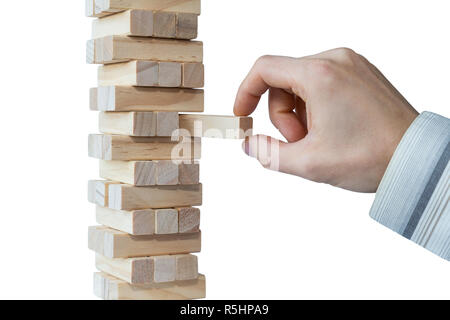 Imprenditore il canto prendendo il primo blocco o mettendo ultimo blocco di robusta torre di blocchi di legno. Concetto foto di pianificazione, tenendo conto dei rischi e la definizione di strategie Foto Stock